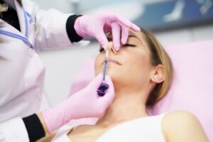 mujer recibiendo tratamiento alectomia fosas nasales clinica estetica taccone santiago chile