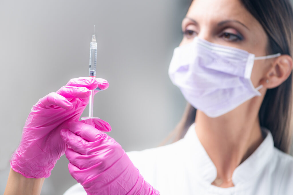 mujer sosteniendo aguja acido hialuronico tratamiento facial clinica estetica taccone santiago chile