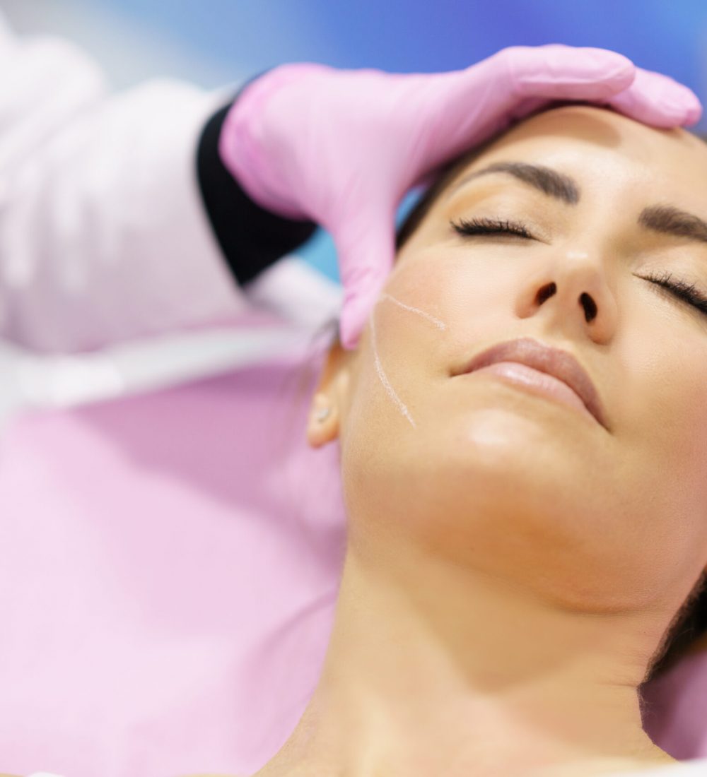 mujer recibiendo tratamiento facial rostro inyeccion clínica de medicina estética taccone las condes santiago chile