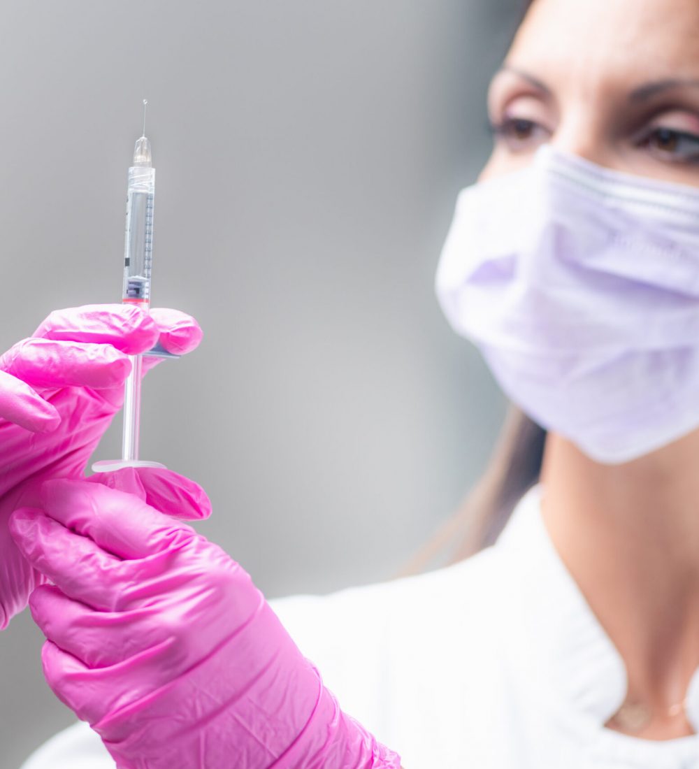 mujer sosteniendo aguja acido hialuronico tratamiento facial clinica estetica taccone santiago chile